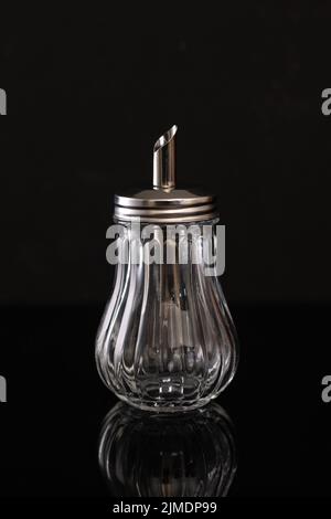 Glass sugar bowl on black background whith reflection Stock Photo