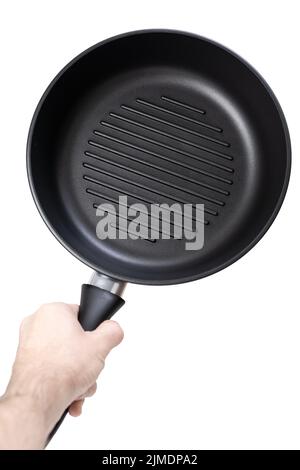 Man holding a cast iron frying pan of grill pan type isolated on white background Stock Photo