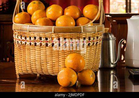 Ripe oranges in a bamboo basket. Stock Photo