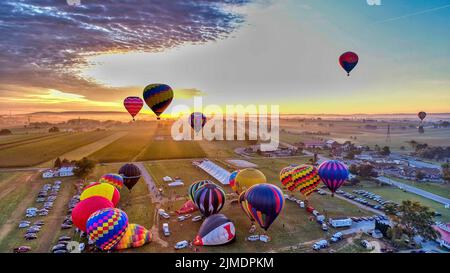 Hot Air Balloons Taking Off at Sunrise Stock Photo