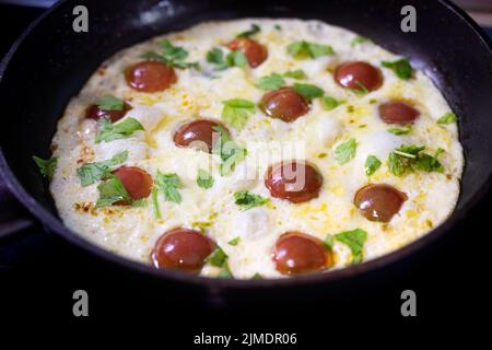 Omelet with cherry tomatoes and basil in pan. Frittata Stock Photo