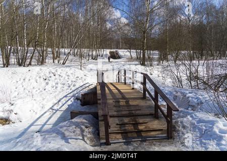 A bridge over a stream at the bottom of a small ravine. Stock Photo