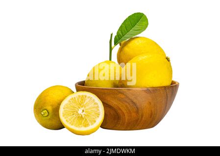 Lemons whole and half with leaves in wooden bowl on white background. Stock Photo