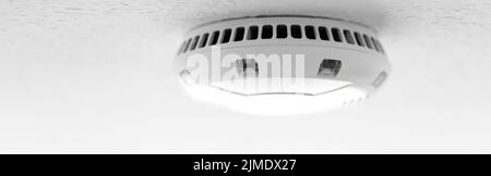 A modern smoke-alarm as panorama on the ceiling Stock Photo