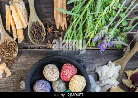 Set of aromatic incense and natural flowers and herbs on rustic wood Stock Photo
