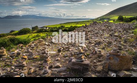 Field with many rock piles, rock balancing with a view on Dingle peninsula Stock Photo
