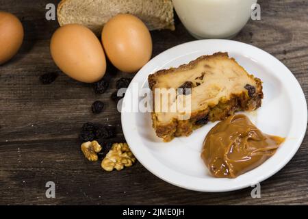 Portion of Bread pudding, made with milk, eggs, stale bread and fruits and Argentine dulce de leche Stock Photo