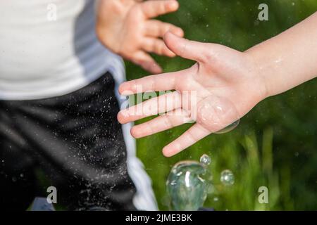 Children with soap bubbles. Soap bubbles and children's hands. Stock Photo