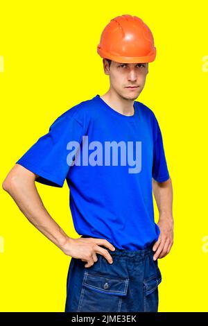 Studio portrait of a confident worker in a construction helmet looking at the camera and holding his hands on his belt. Stock Photo