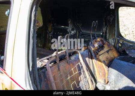 EXETER, DEVON, UK -  MARCH 31, 2022 a Peugeot Partner vehicle abandoned on a quiet country lane and burnt out with smashed windscreen Stock Photo