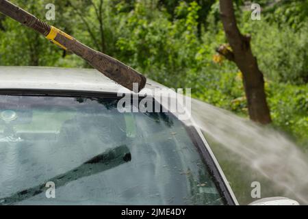 Washing the windshield from dirt. The car is washed by the pressure of the walls. Stock Photo