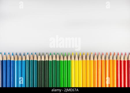 Row of colored pencils on a white sheet of paper Stock Photo