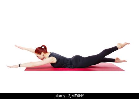 Pilates or yoga. A slender athletic girl performs an exercise to strengthen the back muscles. Visual aid. Mind and body Stock Photo