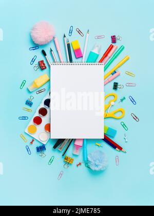 School supplies and empty notebook on blue bckg Stock Photo