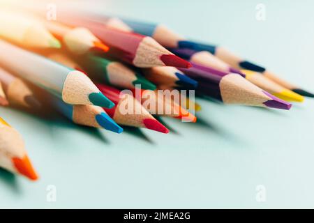 Sharp colored pencils for drawing lie on the table. Accessories for creativity and artists. background. Stock Photo