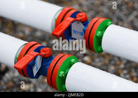 New shut-off valves pipeline close-up. These are white pipes and a red valve. Stock Photo