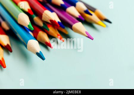 Sharp colored pencils for drawing lie on the table. Accessories for creativity and artists. background. Stock Photo