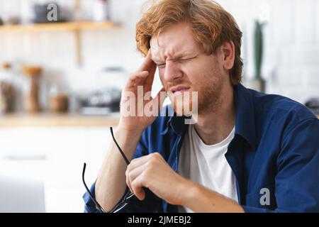 portrait of tired stressed man having headache feeling sick pain depression overwork concept Stock Photo