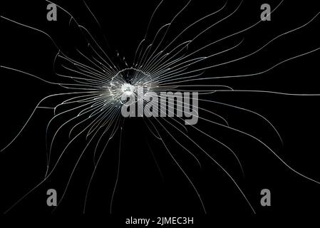 Cracked line on broken glass isolated on black background. The texture of the impact on the glass. Stock Photo