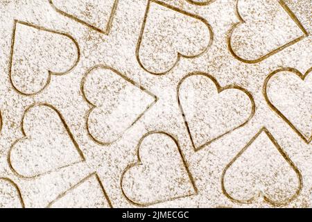 Background of ginger dough with cut heart shaped cookies, sprink Stock Photo
