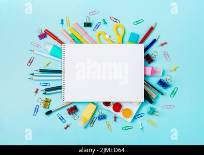 School supplies and empty notebook on blue bckg Stock Photo