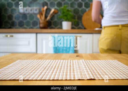 Woman working in blurred kitchen interior and wooden desk space home background Stock Photo