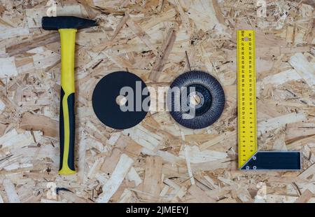 The word TOOL made up of letters collected from construction tools. Background of OSB building board. Stock Photo
