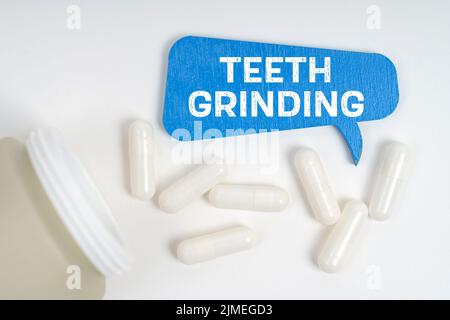 Medicine and health concept. On the table are pills and a blue sign that says - Teeth grinding Stock Photo