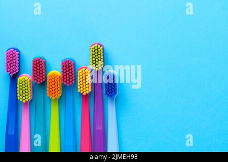 Colorful Toothbrushes Over Blue Paper Background Stock Photo