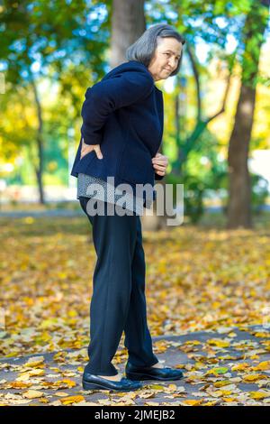 Senior woman suffering from backache outdoors Stock Photo