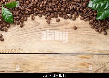 Coffee Beans With Green Leaves On Wooden Stock Photo