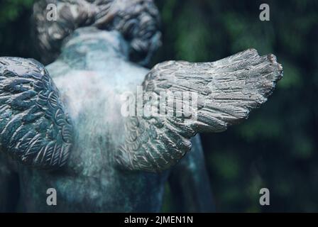 Angel wings. Fragment of bronze sculpture at old cemetery. Stock Photo