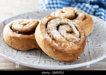 Cinnamon rolls buns. Kanelbulle Swedish dessert on wooden table Stock Photo