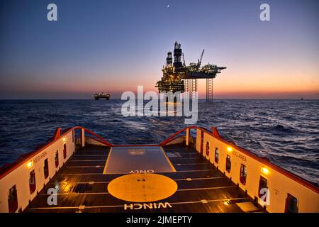 Supply vessel going for cargo operations for oil production plant. Dynamic positioning vessel going for cargo operations for jack up rig. Stock Photo