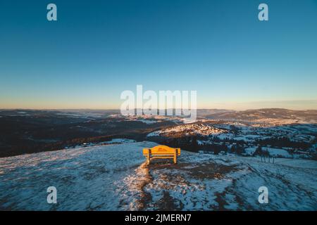 Bench on Mount Ochodzita in the Koniakow area of the Polish Beskydy Mountains illuminated in the morning light. Beautiful quiet resting place. Stock Photo