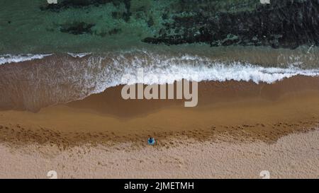 A man on a sandy beach controlling the drone with remote control Stock Photo