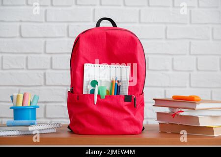 Back to school, backpack with school supplies and stationery, textbooks and notebooks on table. Stock Photo
