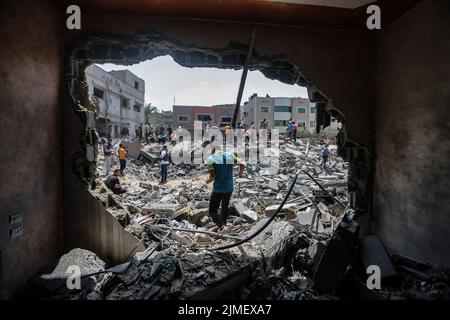 Gaza City, Palestinian Territories. 06th Aug, 2022. Palestinians inspect the ruins of a collapsed building destroyed during an Israeli air strike. The Israel Defense Forces said on Saturday they are preparing for a 'week of operations' against Palestinian militants, as a barrage of retaliatory rockets were fired from Gaza overnight following the targeted killing of a Palestinian militant leader. Credit: Mohammed Talatene/dpa/Alamy Live News Stock Photo