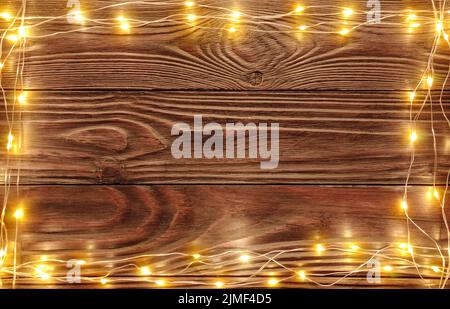 Christmas lights on dark wooden background flat lay mockup frame for greeting card Stock Photo