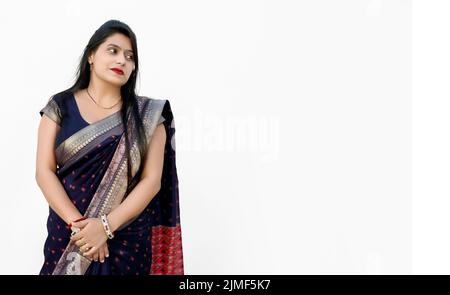 A Portrait of a happy woman of Indian origin wearing traditional dress sari isolated on white background Stock Photo