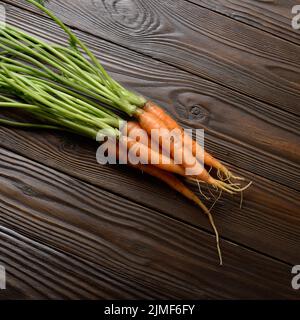 Top view at Fresh organic carrots on kitchen wooden rustic table Stock Photo