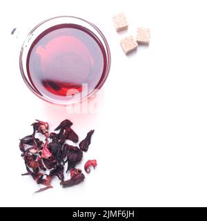 Top view of Hibiscus Tea cup with petals and sugar cubes aside on white background Stock Photo