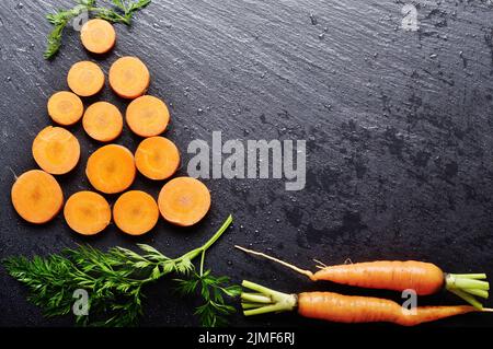 Top view at stylised christmas tree made of carrots on slate stone tray Stock Photo