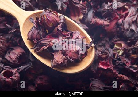 Top view of Dry Hibiscus petals in wooden spoon background closeup Stock Photo