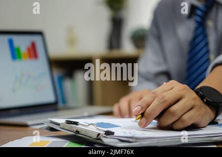 businessman data document graph chart report marketing research development working at office with laptop. Stock Photo