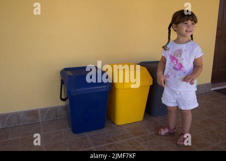 Little girl with recycle trash bins in kitchen Stock Photo - Alamy