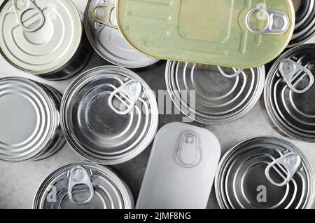 Flat lay view at various canned foods in tin cans on kitchen table, non-perishable, long shelf life food for survival in emergen Stock Photo