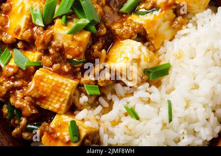 Authentic traditional Chinese food mapo tofu dish with pork chives and steamed rice closeup Stock Photo