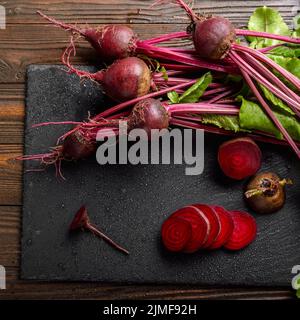 Top view at fresh organic beets with leaves on wooden rustic table close up view Stock Photo