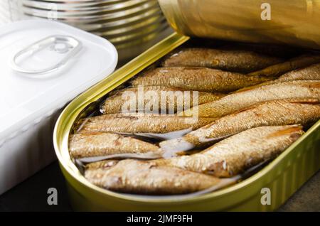 Canned smoked fish sprats in just opened tin can. Non-perishable food Stock Photo